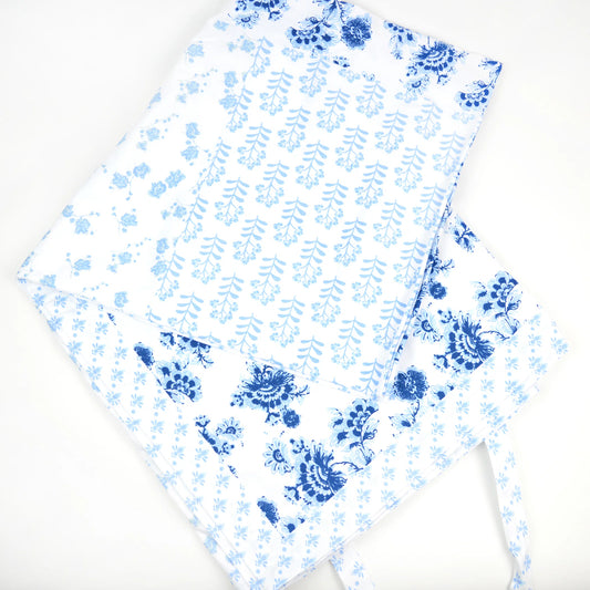 White cotton picnic blanket with blue floral pattern on a white background