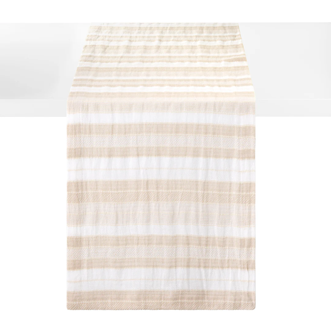 A striped woven cotton table runner with alternating horizontal stripes of beige and white, shown hanging against a white background.
