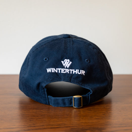 Back of a navy blue baseball hat with the Winterthur logo in white and an adjustable strap with a gold-tone buckle
