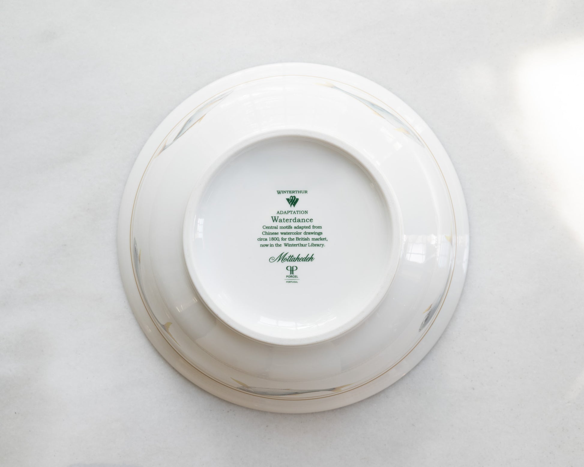 Printed logo and pattern information printed on the underside of a white porcelain bowl