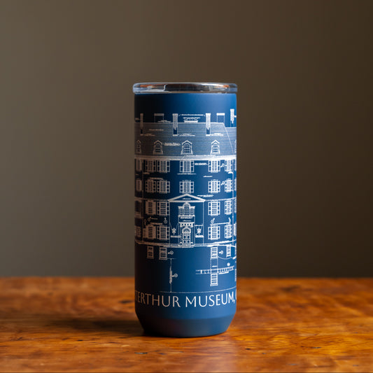 Blue tumbler featuring an architectural sketch and the words "Winterthur Museum, Garden & Library"  under design on a wooden tabletop and dark background