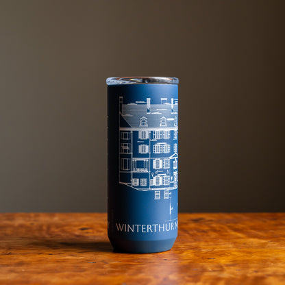 Blue tumbler featuring an architectural sketch and the words "Winterthur Museum, Garden & Library"  under design on a wooden tabletop and dark background