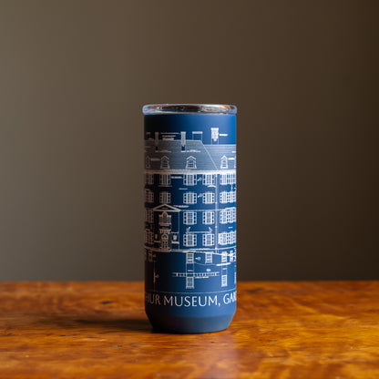 Blue tumbler featuring an architectural sketch and the words "Winterthur Museum, Garden & Library"  under design on a wooden tabletop and dark background