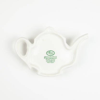 Underside of a white ceramic teapot-shaped spoon rest with a visible brand logo on a white background