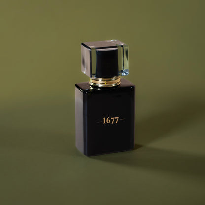 Black cologne bottle featuring '1677' in gold on the front against an olive green background