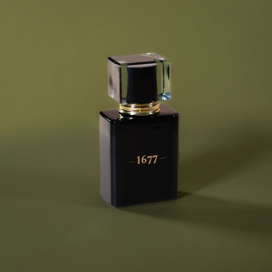 Black cologne bottle featuring '1677' in gold on the front against an olive green background