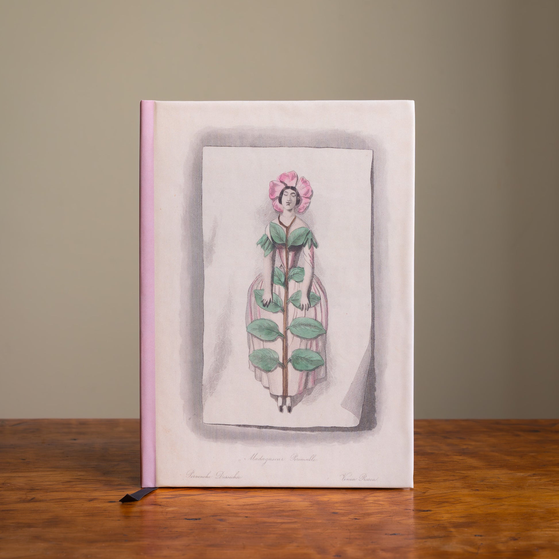 Notebook with a floral illustration on a wooden surface