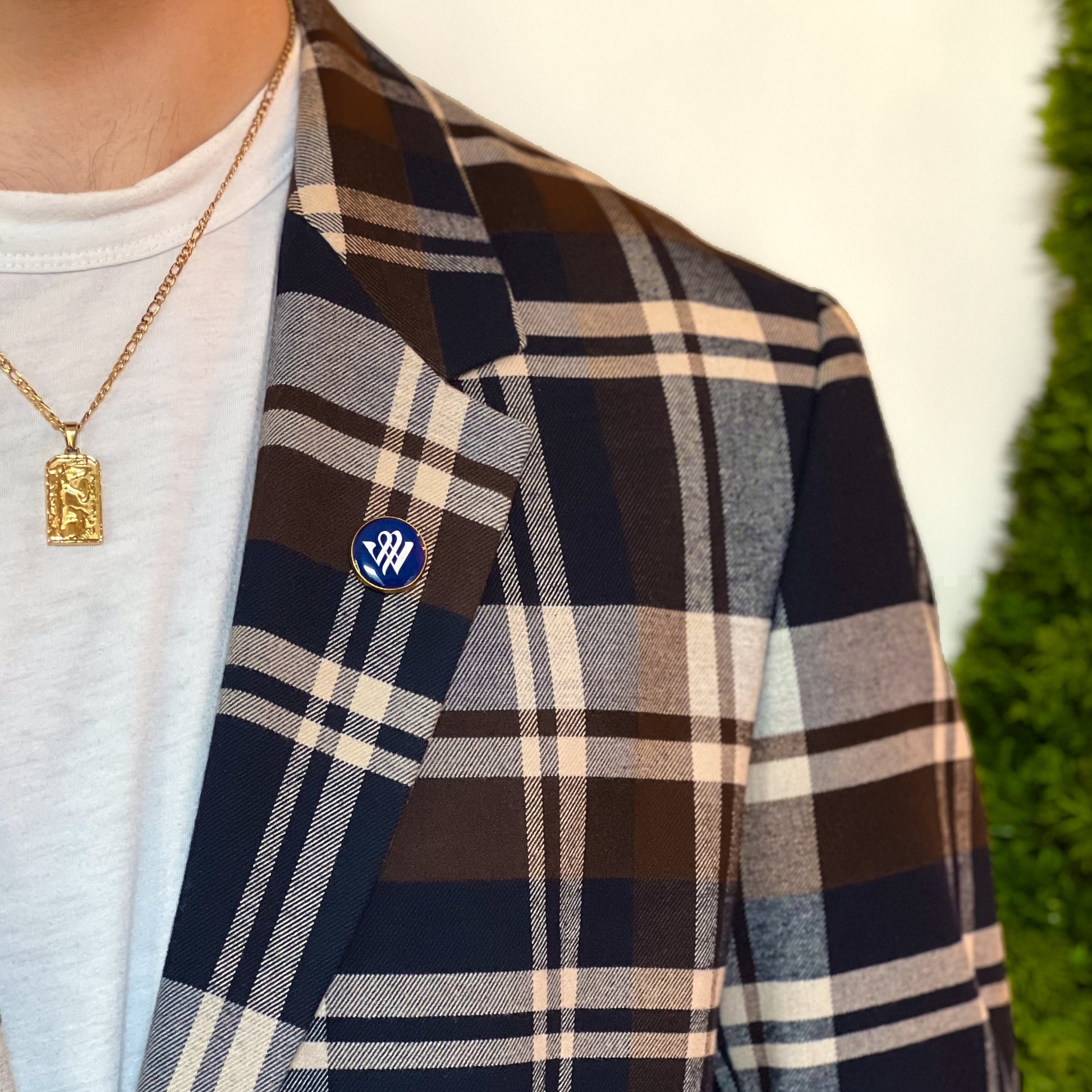 Detail image of a person wearing a blue and gold Winterthur lapel pin on the lapel of their blazer.