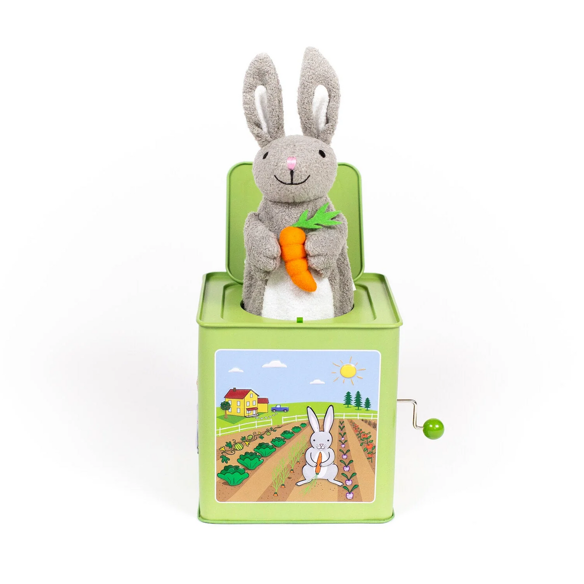 Green metal jack-in-the-box featuring an illustration of a bunny on a farm with a plush gray bunny holding a carrot sticking out of the top.