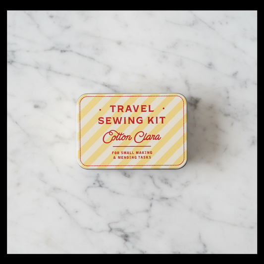Travel sewing kit with 'Cotton Clara' branding on a white marble tabletop