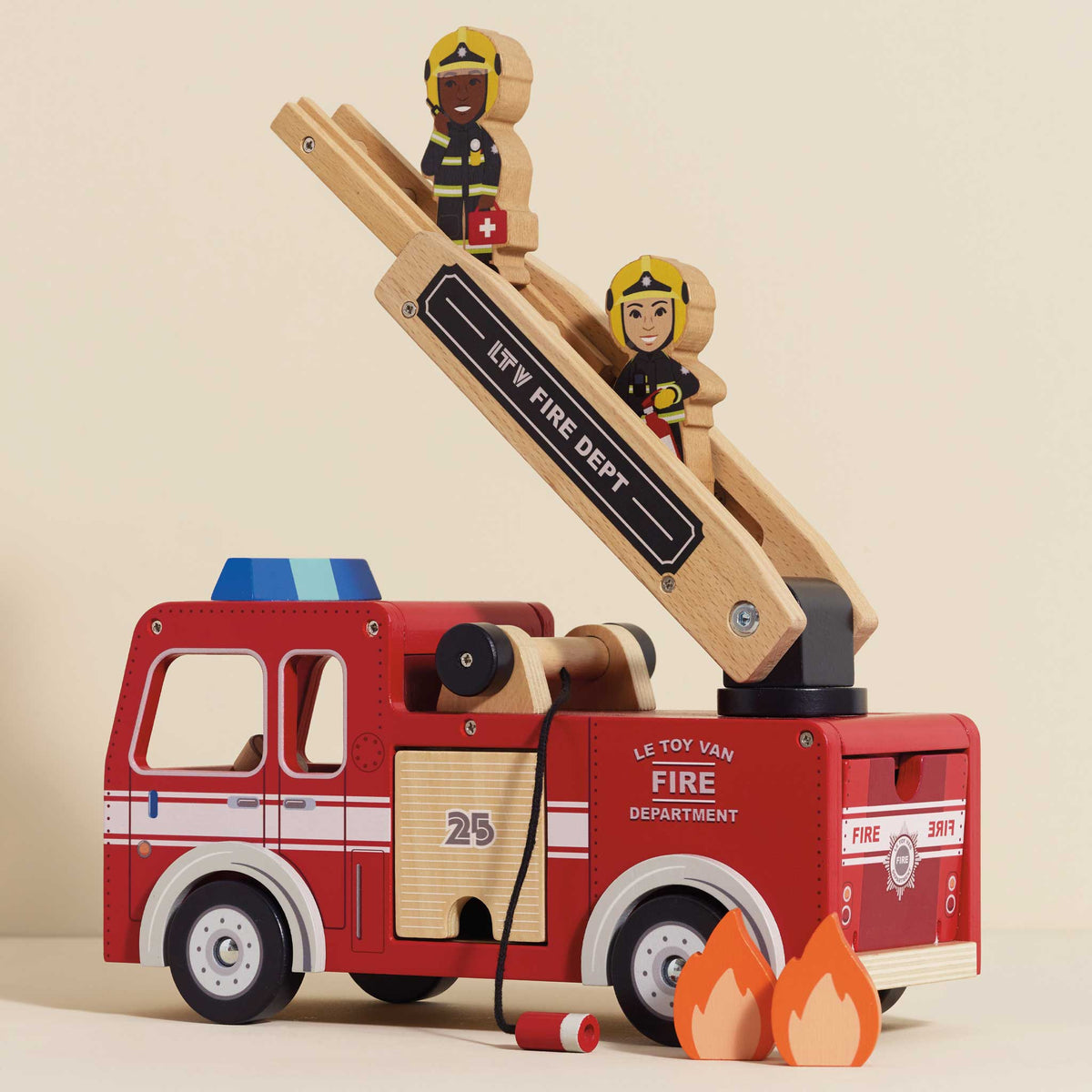 Wooden toy fire truck with ladder and firefighters on a beige background