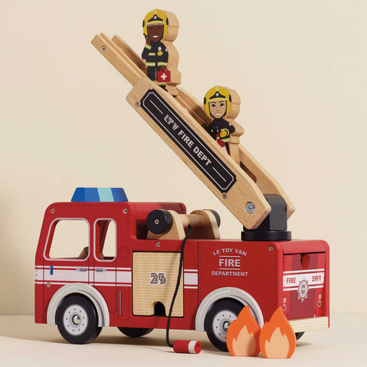 Wooden toy fire truck with ladder and firefighters on a beige background