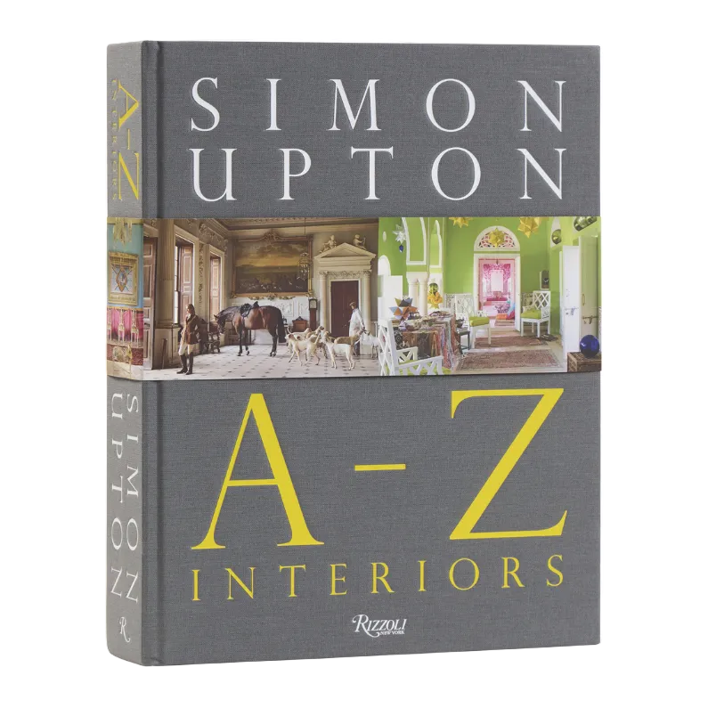 A gray hardcover book with to images of decorated rooms on the cover entitled A-Z Interiors by Simon Upton.