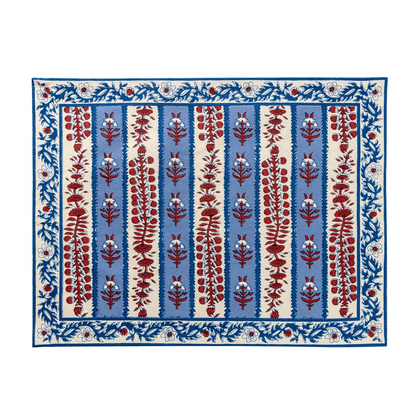 Rectangular cloth placemat with a blue and off-white striped pattern and decorated with block printed navy blue and red floral motifs laid flat against a white background