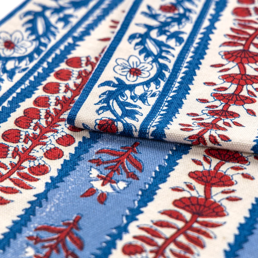 Close-up detail of block printed floral table runner red, off-white, and blue.