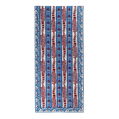 Red, off-white and blue floral block printed table runner against a white background.