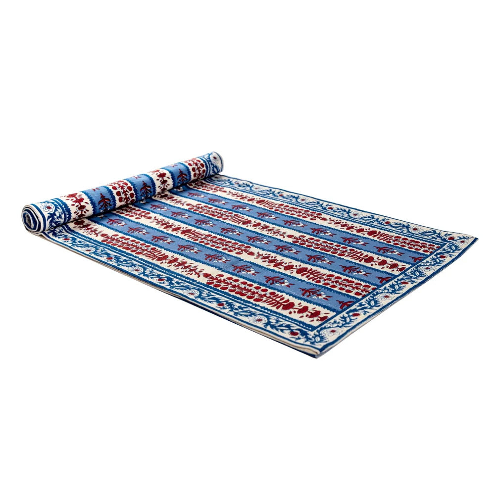 Red, off-white and blue floral block printed table runner against a white background.