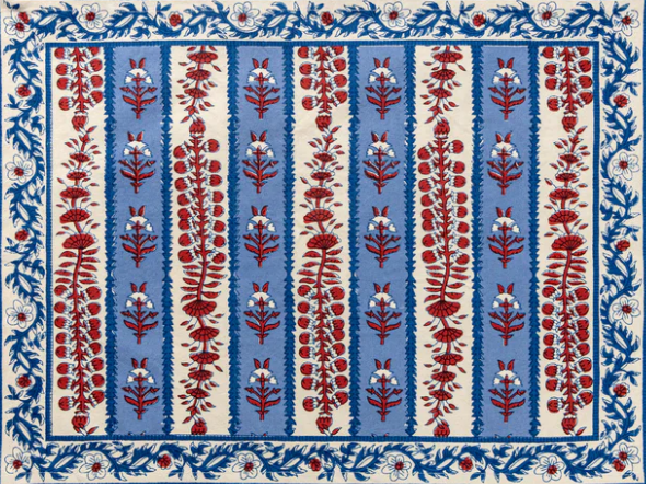 Block printed placemat with red floral patterns on a blue and white striped background