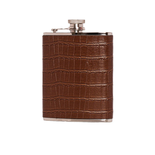 A stainless steel flask wrapped in a brown crocodile-embossed leather sleeve against a white background.