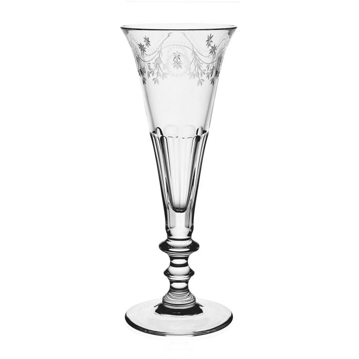Clear crystal flute with intricate garland pattern etched on rim displayed against a white background