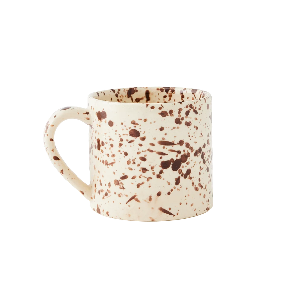 A straight-sided round mug with a warm cream base and translucent brown splattered pattern, shown against a plain white background.