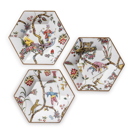 Three hexagonal ceramic plates with colorful animal and floral designs on a white background