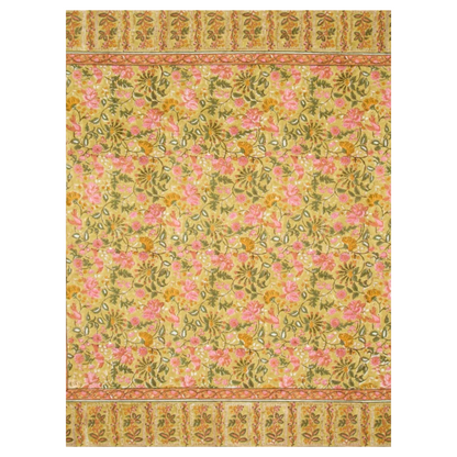 A mustard-colored tablecloth with a traditional floral pattern in olive green, saffron, and rose pink, and a contrasting repeated leaf border laid flat against a white background.