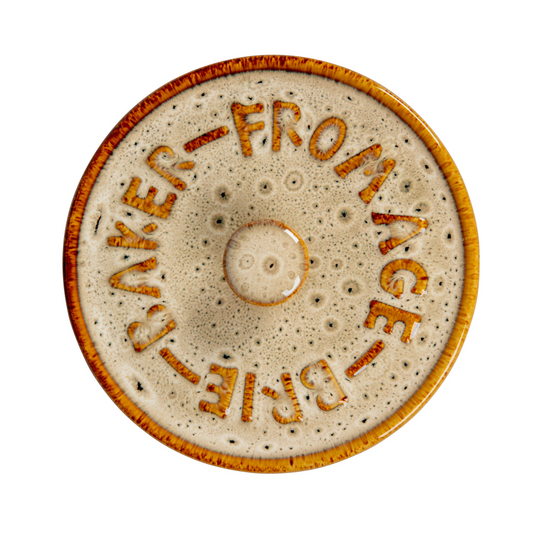 Top view of beige and brown speckled stoneware lid with the raised words 'FROMAGE-BRIE-BAKER' 