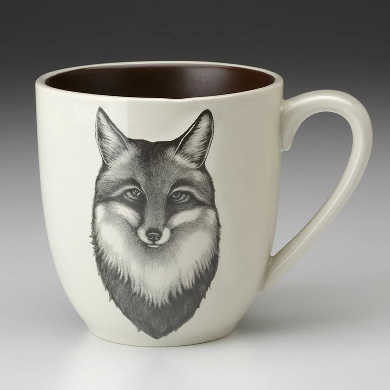 An off-white stoneware tapered mug featuring a sketch of fox portrait in black and a dark brown interior.