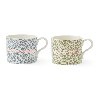 Two patterned ceramic mugs featuring intricate leaf designs, one in blue and one in green, both with the phrase 'LOVE IS ENOUGH' written across the front in red text.