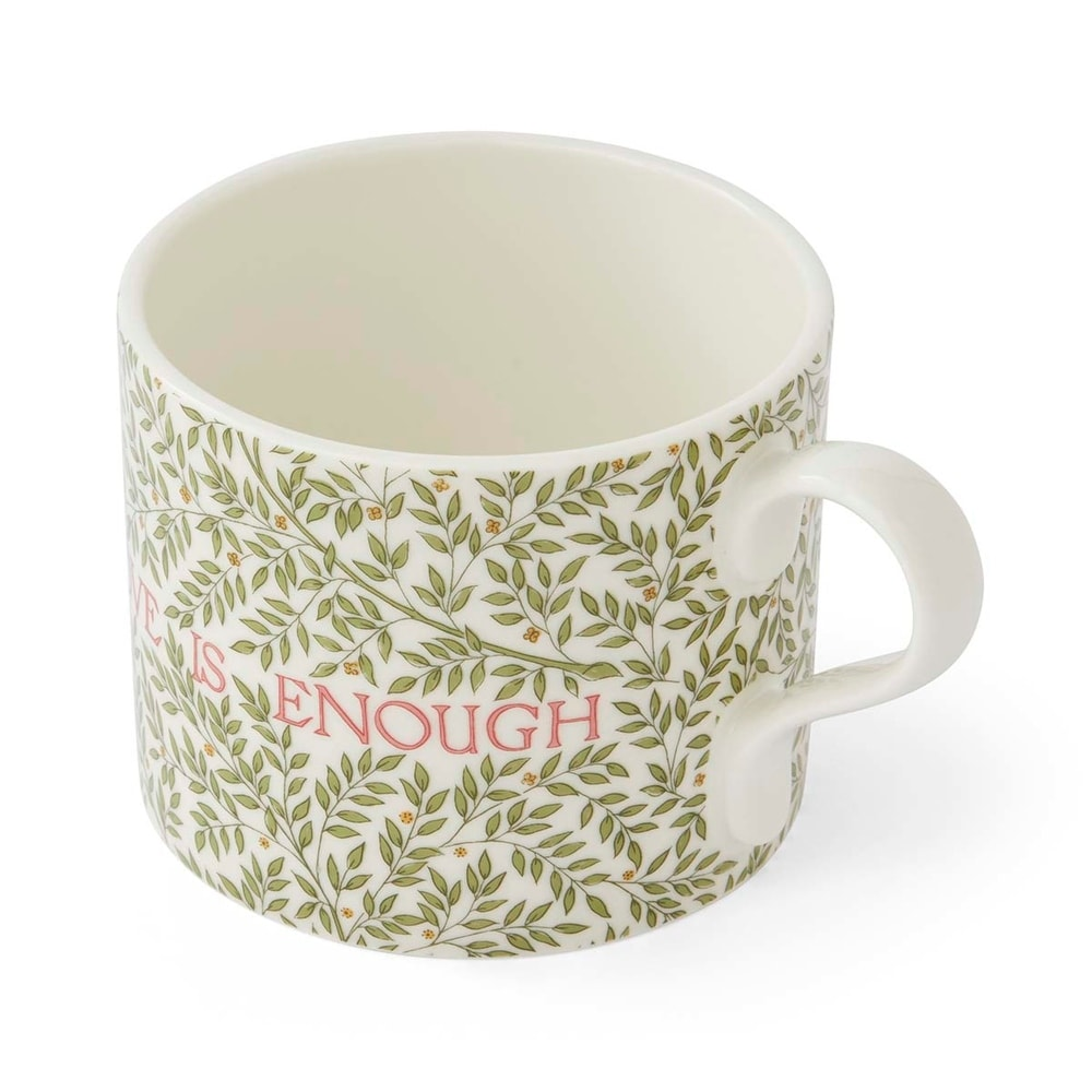 A white ceramic mug decorated with a dense pattern of small green leaves and branches. The text "LOVE IS ENOUGH" is written horizontally across the lower half in red capital letters, partially woven into the foliage design. The mug features a standard curved handle on the right and is set against a clean, plain white background.