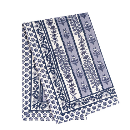A folded cotton tea towel featuring a classic Indian floral block print pattern in navy blue and light blue on off-white.