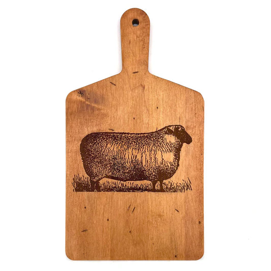 Wooden cutting board with a engraved sheep design on a white background