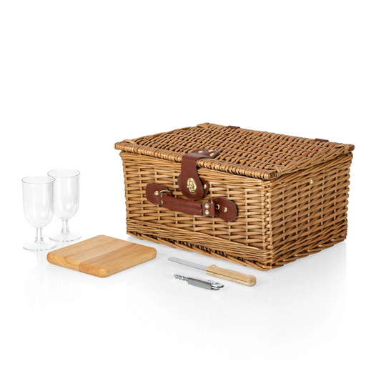 Wicker picnic basket with accessories against a white background