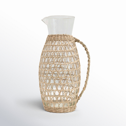 Clear glass pitcher with a natural woven sleeve and handle