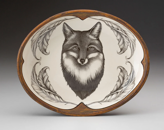 An off-white oval serving plate with a rust-brown rim featuring a sketch of a fox portrait framed with leaves in black 