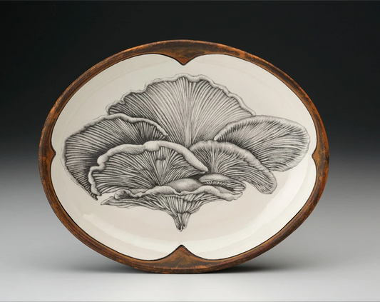 An off-white oval serving plate with a rust-brown rim featuring a sketch of a shelf mushroom in black 