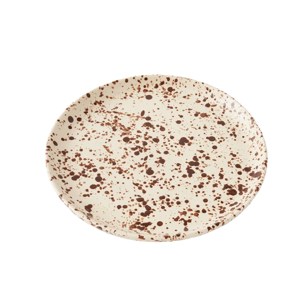 Round ceramic plate with a cream-colored base decorated with a translucent brown splattered pattern on a white background