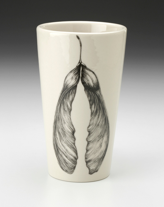 An off-white stoneware tapered travel mug featuring a sketch of two connected maple seeds in black.
